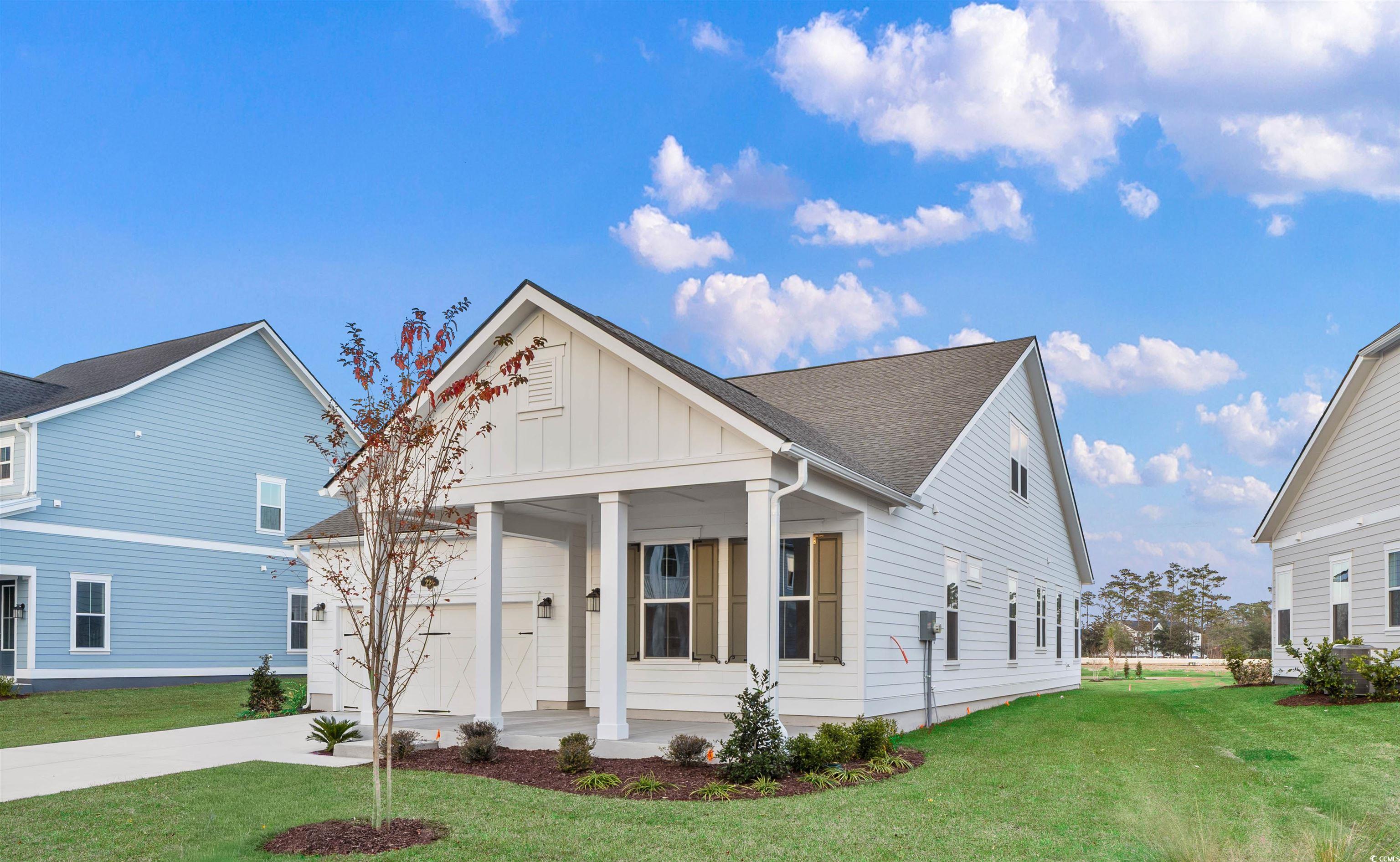 224 Atlantic Breeze Street Myrtle Beach, SC 29572 - Photo 2 of 39 View of front of house featuring board and batten siding, a porch, a front lawn, and concrete driveway