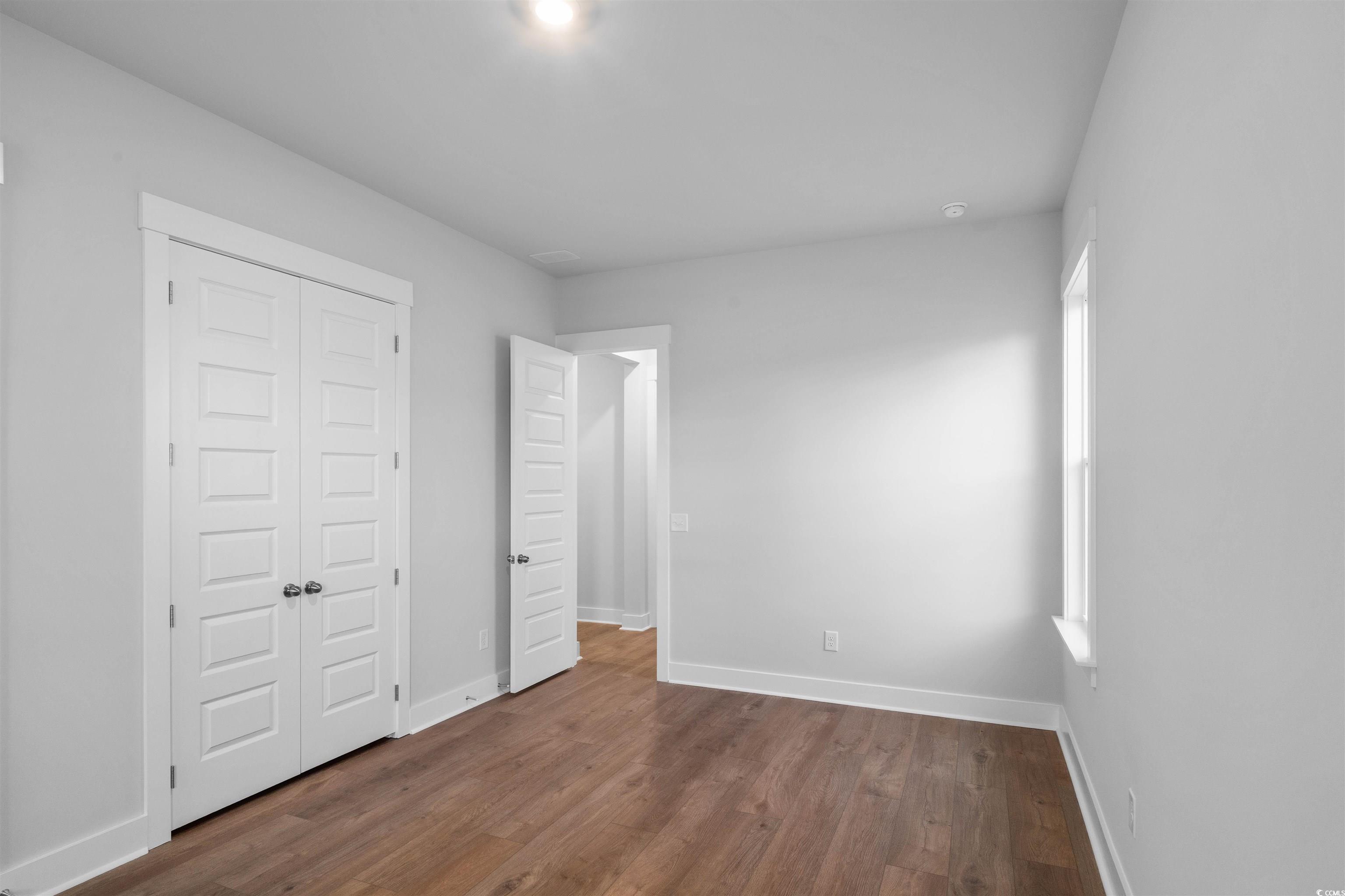 224 Atlantic Breeze Street Myrtle Beach, SC 29572 - Photo 8 of 39 Unfurnished bedroom with dark wood-type flooring and a closet