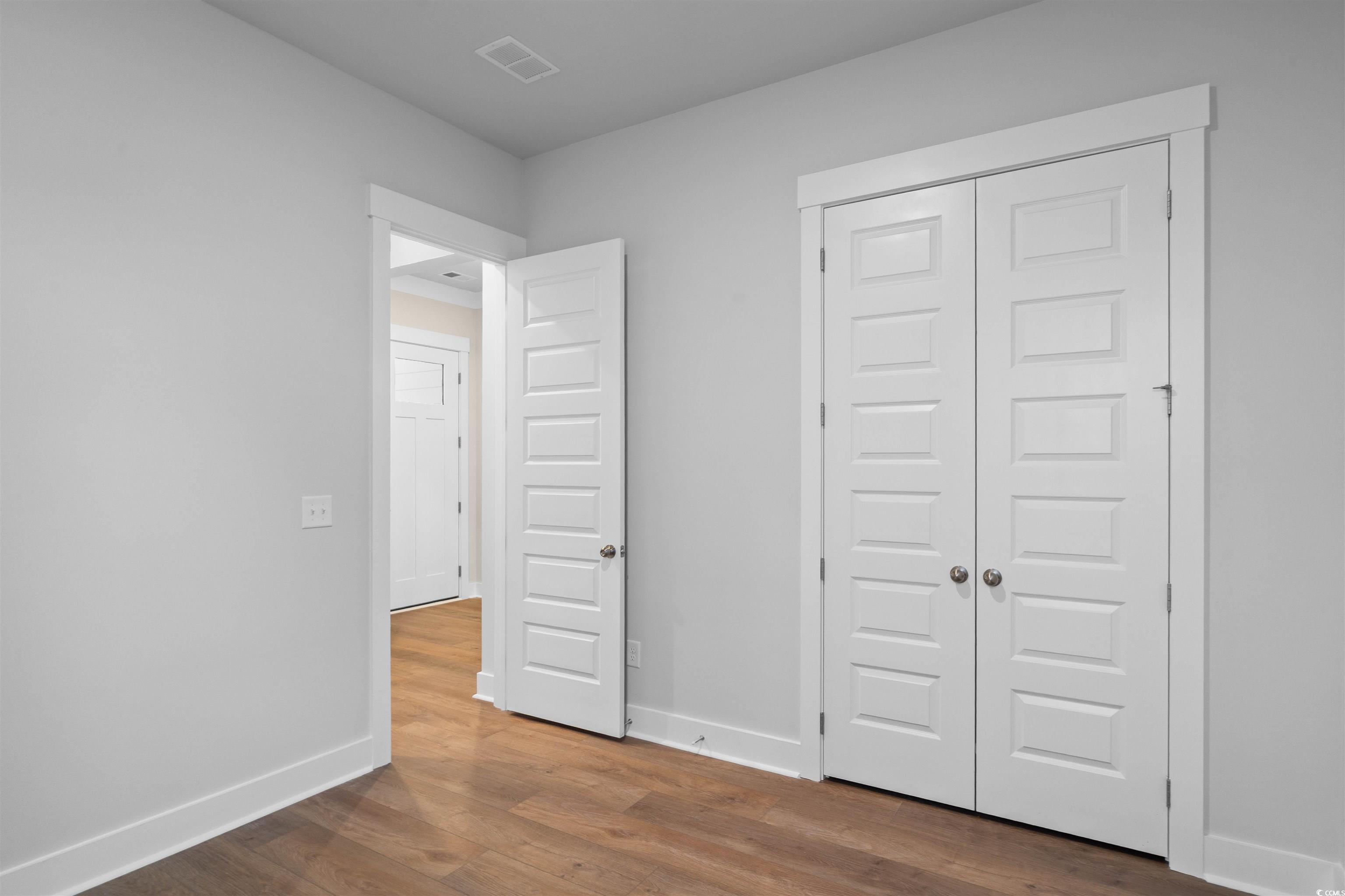 224 Atlantic Breeze Street Myrtle Beach, SC 29572 - Photo 9 of 39 Unfurnished bedroom with dark wood finished floors and a closet
