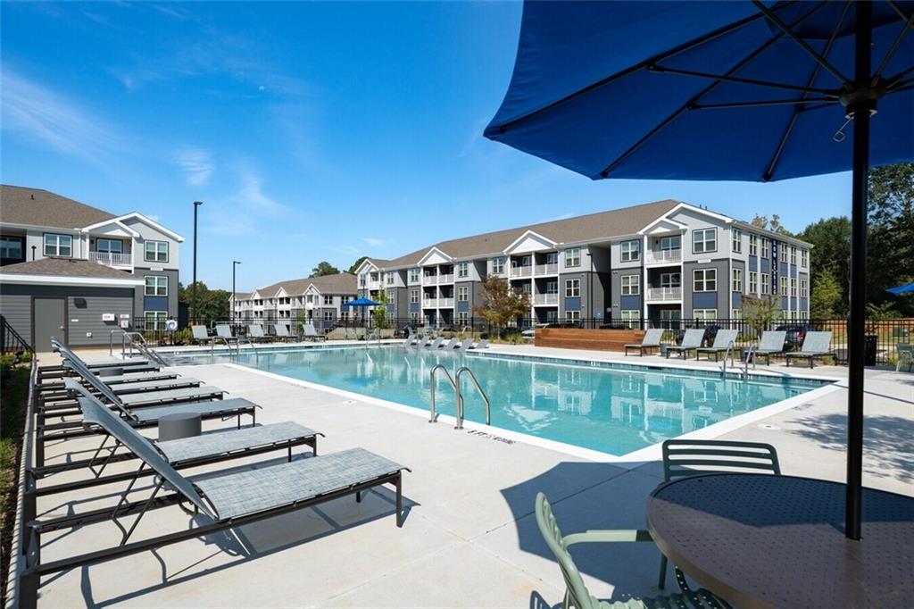 191 Commerce Drive, Unit C1 Villa Rica, GA 30180 - Photo 24 of 30 a view of a patio with couches table and chairs under an umbrella