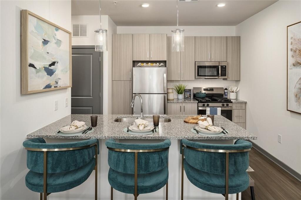 191 Commerce Drive, Unit C1 Villa Rica, GA 30180 - Photo 25 of 30 a kitchen with stainless steel appliances a dining table chairs and stove top oven