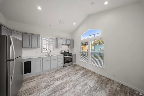 a living room with furniture kitchen view and a refrigerator