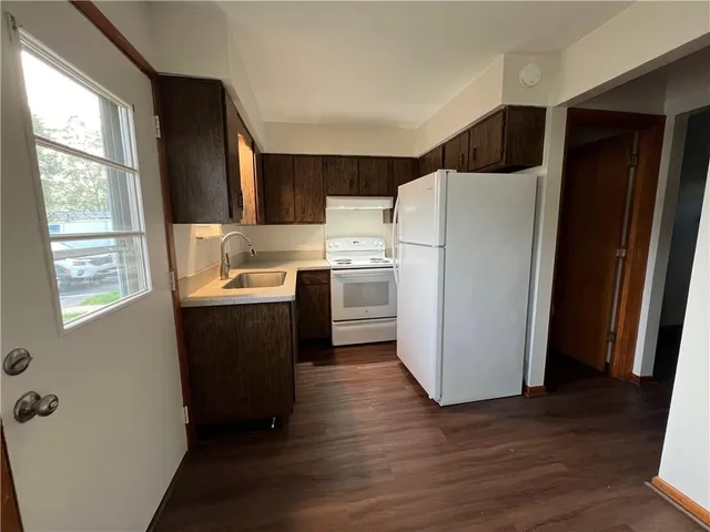 a kitchen with a refrigerator a stove a microwave and a window