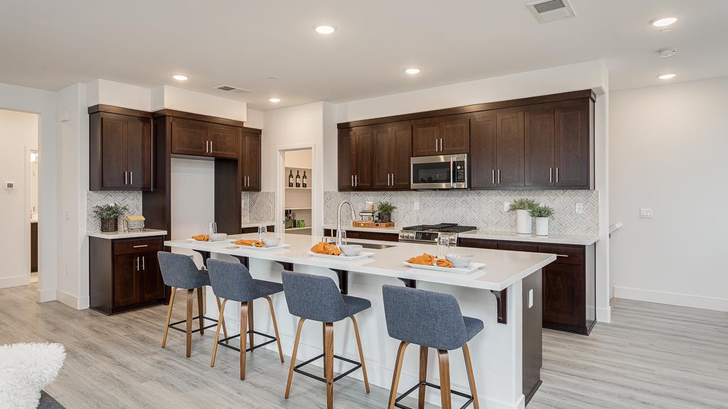 338 Line Street Hayward, CA 94544 - Photo 12 of 25 a kitchen with a refrigerator a stove top oven a sink dishwasher and white cabinets with wooden floor