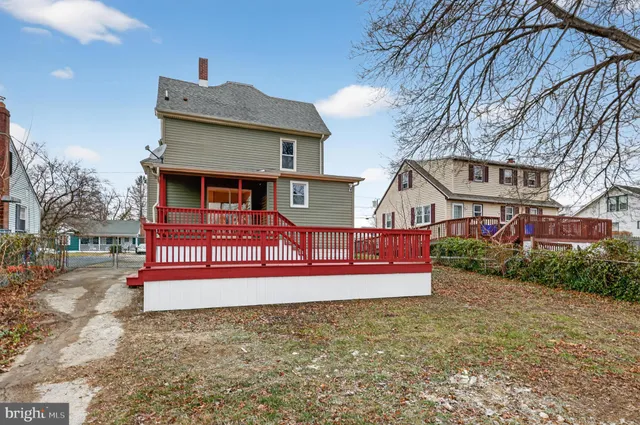 a view of a house with a small yard and wooden fence