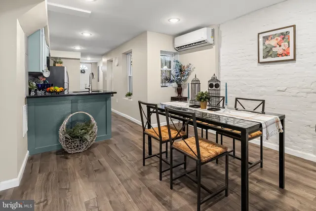 a kitchen with stainless steel appliances granite countertop a table chairs stove and microwave