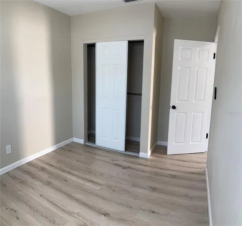 an empty room with wooden floor and closet