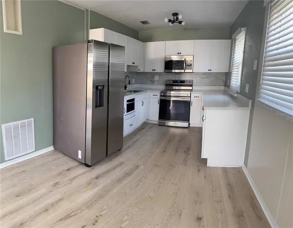 a kitchen with granite countertop a refrigerator a stove top oven a sink and dishwasher