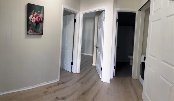 a view of a hallway with wooden floor and closet