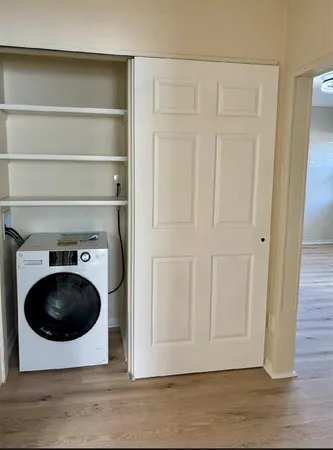 a view of a storage and utility room with wooden floor