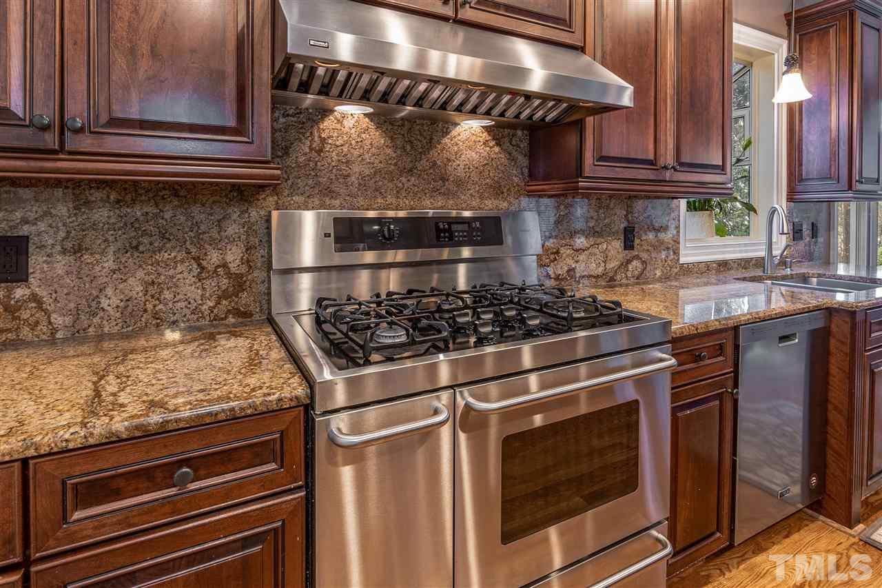 8704 Old Tom Way Raleigh, NC 27613 - Photo 14 of 30 a kitchen with granite countertop a stove and a sink