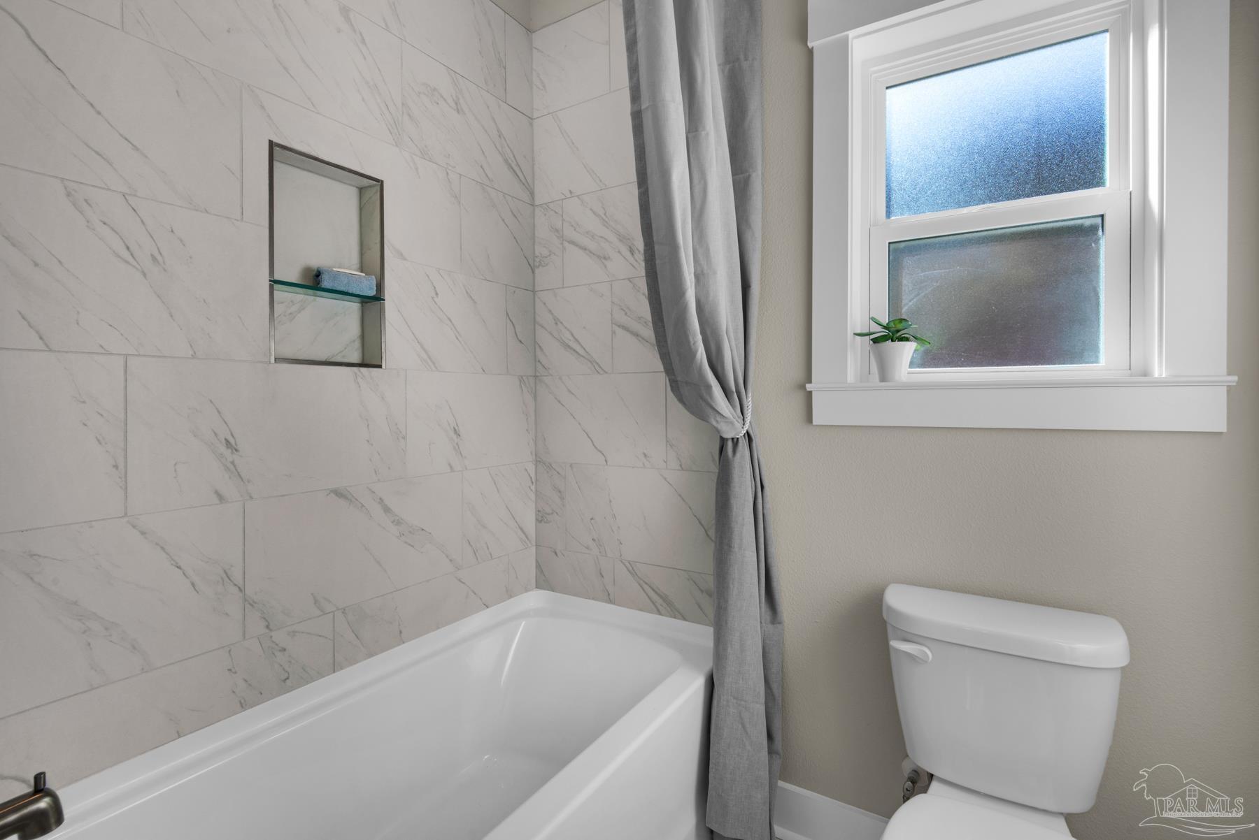 5912 Greenfield Street Pace, FL 32571 - Photo 15 of 47 a bathroom with a toilet and a bathtub