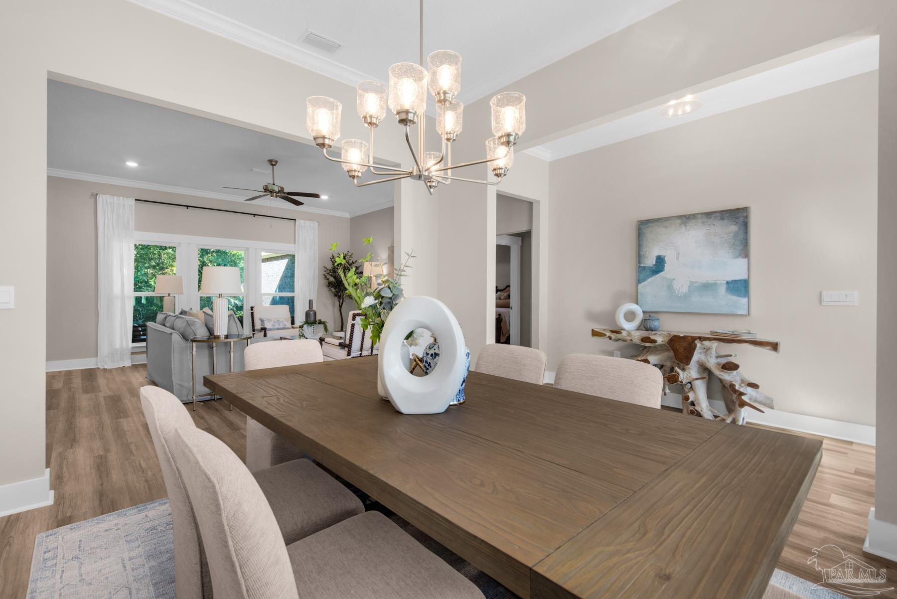 5912 Greenfield Street Pace, FL 32571 - Photo 27 of 47 a view of a dining room with furniture and a chandelier