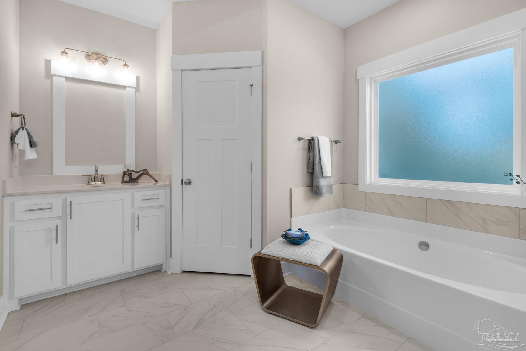 5912 Greenfield Street Pace, FL 32571 - Photo 44 of 47 a bathroom with a tub sink and mirror