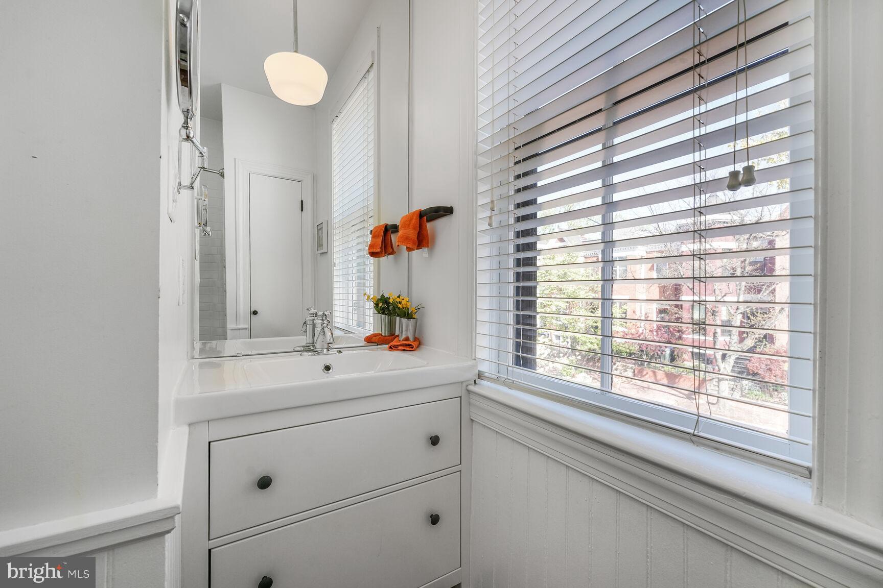 252 10th Street Northeast Washington, DC 20002 - Photo 19 of 31 a bathroom with a sink window and mirror