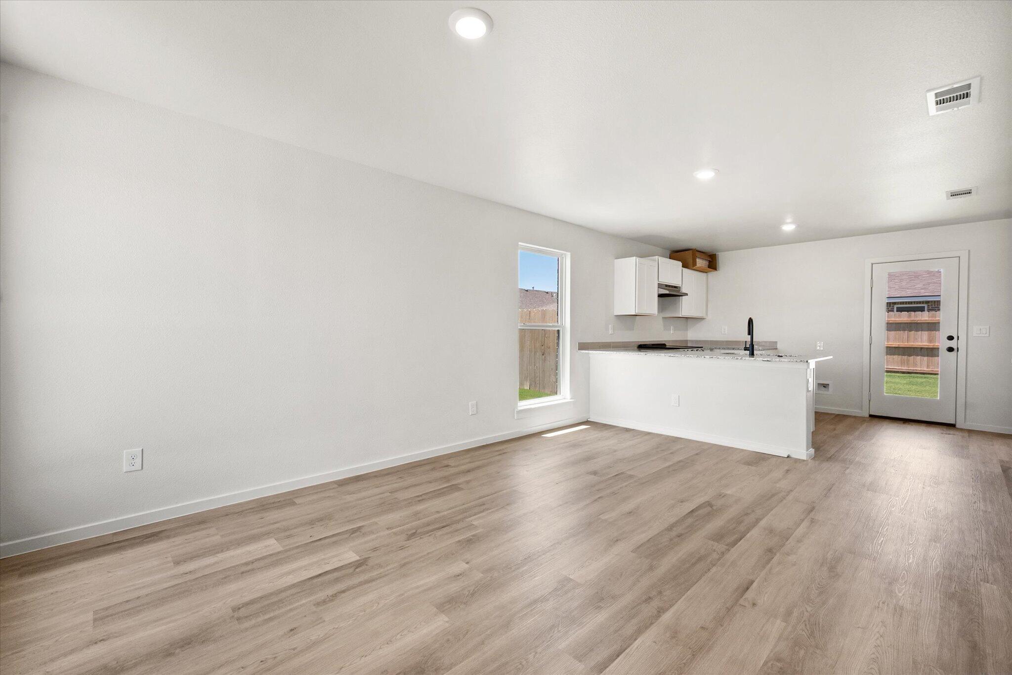 8312 25th Street Lubbock, TX 79407 - Photo 4 of 17 a view of a kitchen with wooden floor and a sink