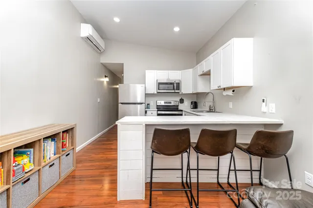 a kitchen with cabinets wooden floor and stainless steel appliances
