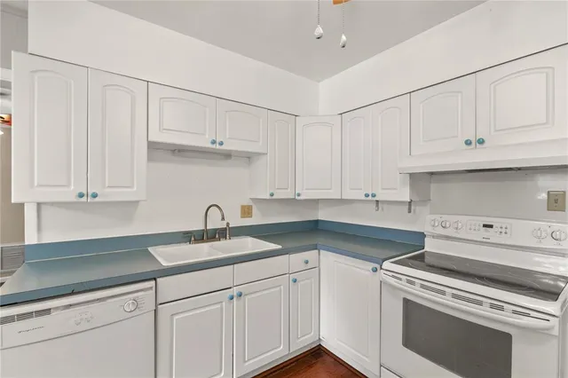 a kitchen with granite countertop white cabinets and a sink
