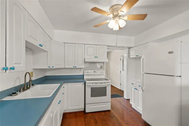 a kitchen with a stove a refrigerator and a sink
