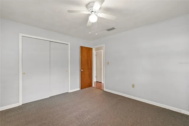an empty room with a ceiling fan and a window