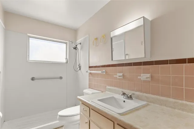 a bathroom with a sink a toilet and shower