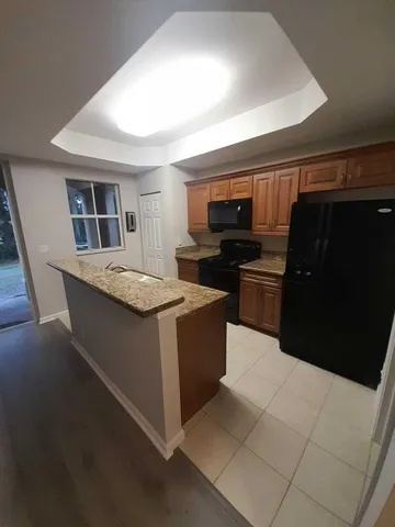 a kitchen with kitchen island stainless steel appliances a sink stove and refrigerator