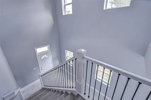 a view of a hallway with wooden floor and stairs