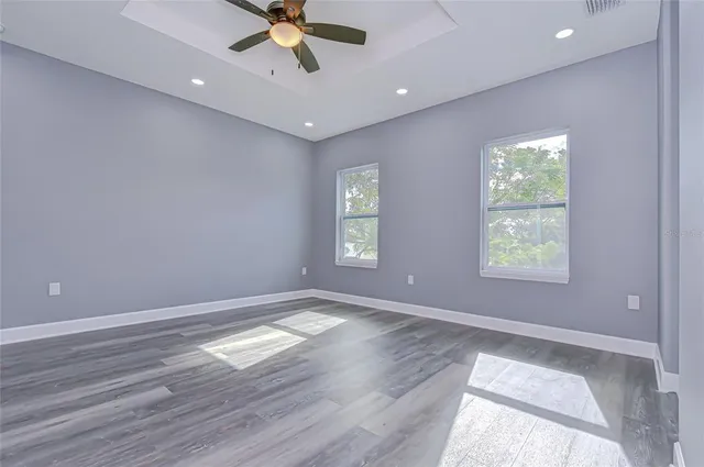a view of an empty room with window and wooden floor