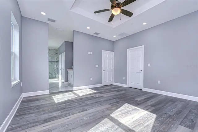a view of an empty room with window and wooden floor