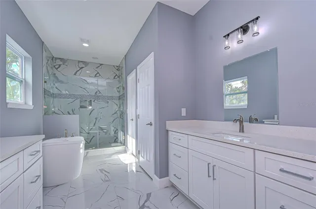a spacious bathroom with a double vanity sink toilet mirror and bathtub