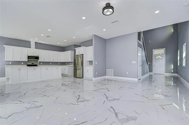 a view of kitchen with refrigerator stove and cabinets