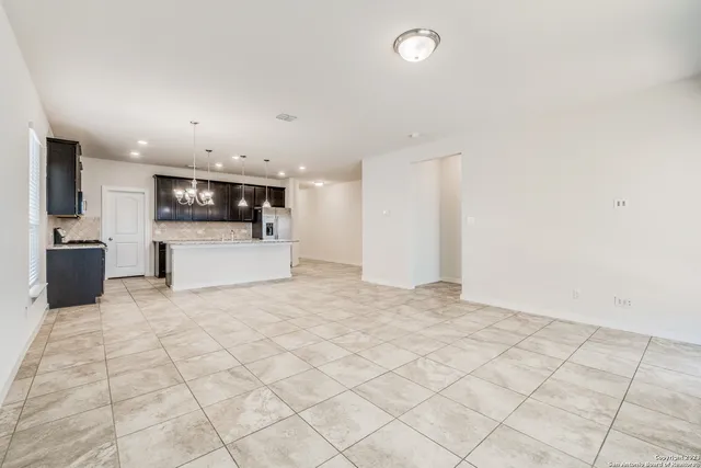 a view of a electric appliances in kitchen and empty room with wooden floor