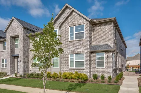 front view of house with a yard and potted plants
