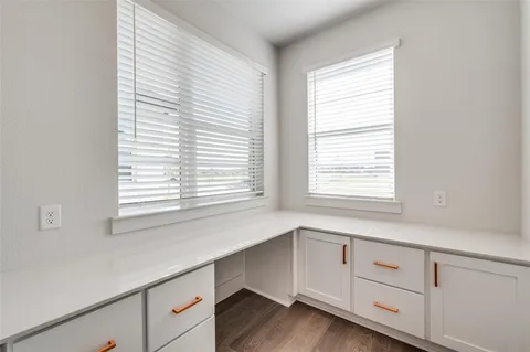 a kitchen with granite countertop white cabinets and a window