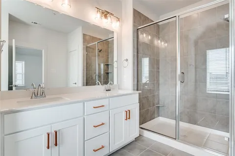 a bathroom with a shower sink and mirror