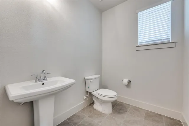 a bathroom with a sink a toilet and a window