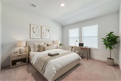 a bedroom with a bed and a potted plant