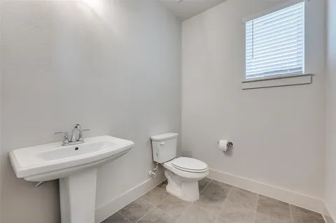 a bathroom with a sink a toilet and a window