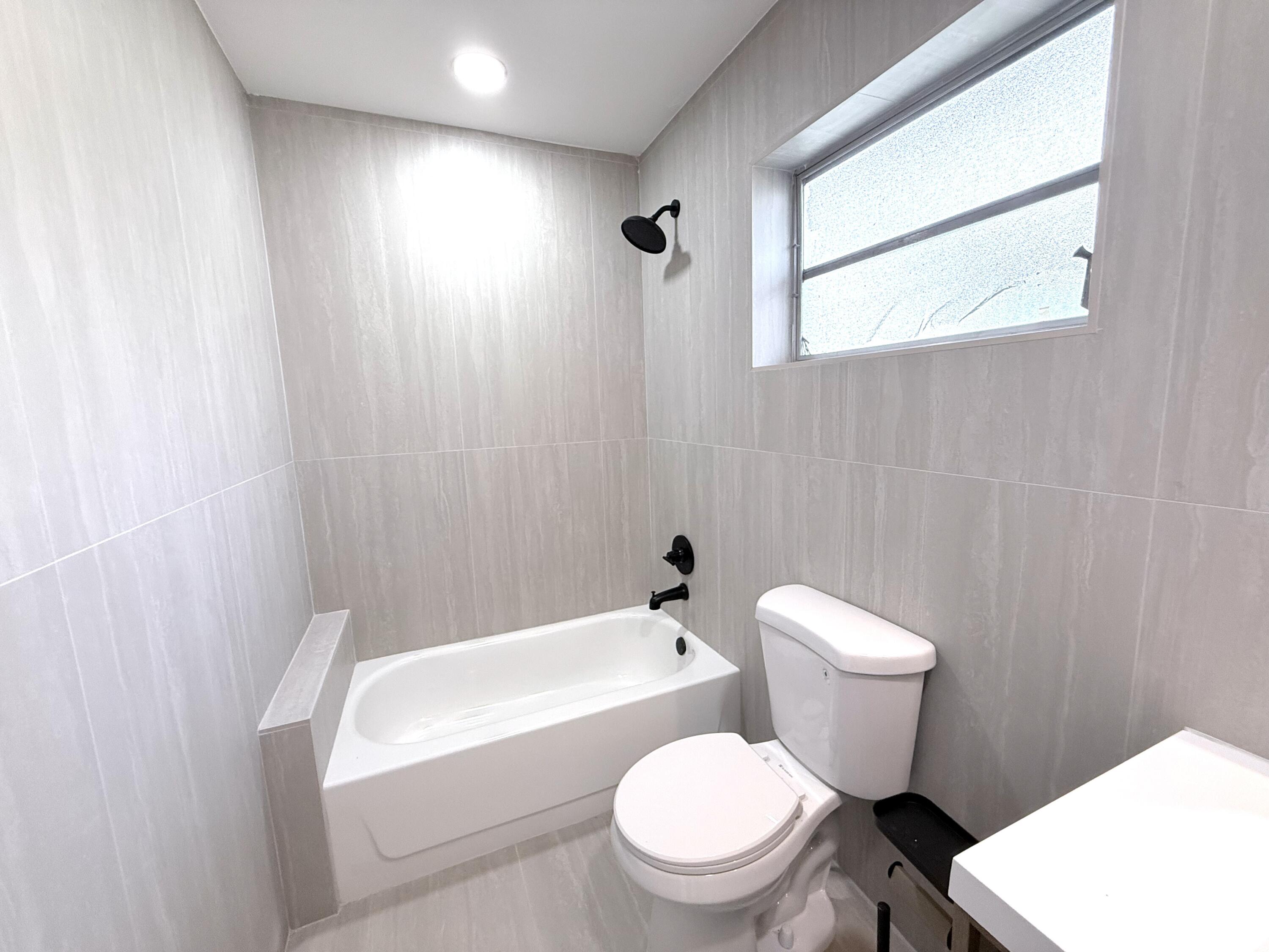 210 West 23rd Street Riviera Beach, FL 33404 - Photo 16 of 20 a white toilet sitting next to a white tub