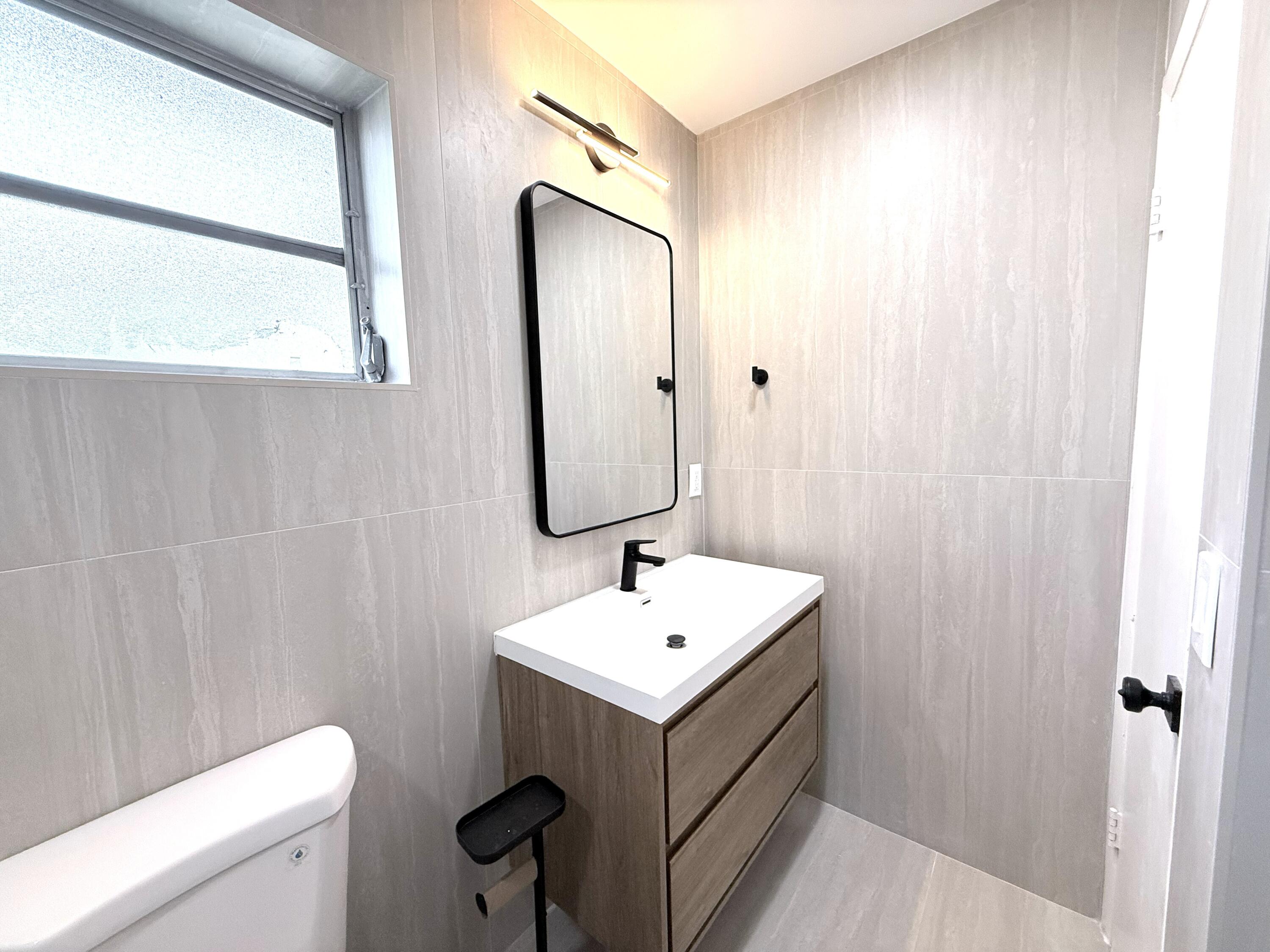 210 West 23rd Street Riviera Beach, FL 33404 - Photo 17 of 20 a bathroom with a sink toilet and mirror