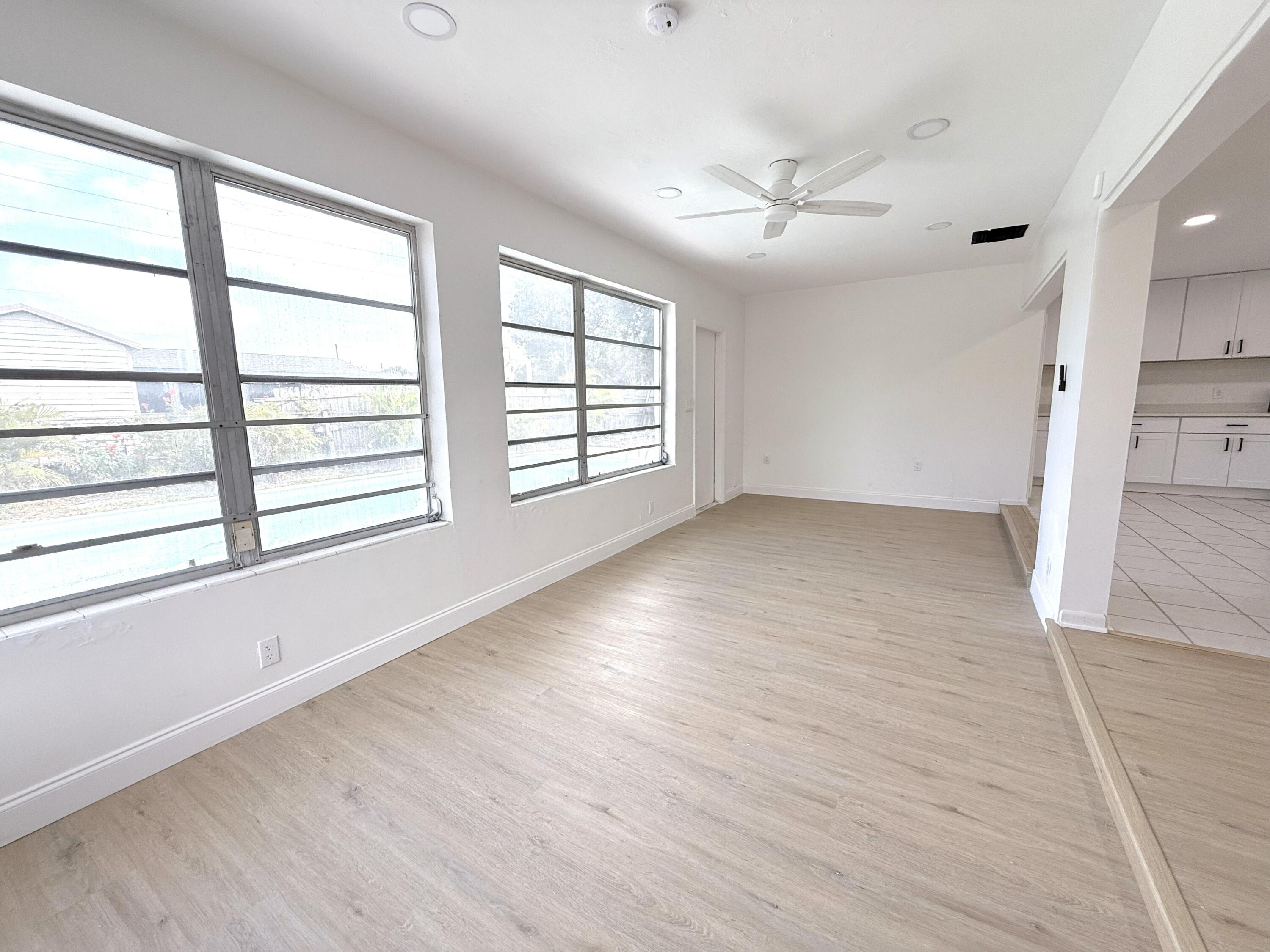 210 West 23rd Street Riviera Beach, FL 33404 - Photo 6 of 20 an empty room with wooden floor and windows