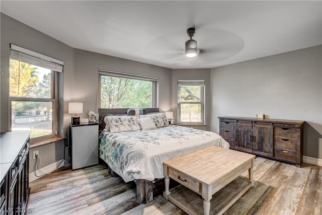 6460 Racel Street Las Vegas, NV 89131 - Photo 48 of 59 Plentiful windows draw natural light into this bedroom featuring rustic wood floors.