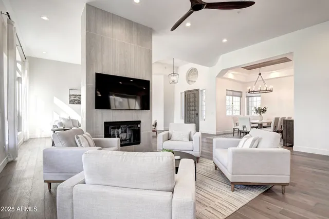 a living room with furniture a flat screen tv and a large window