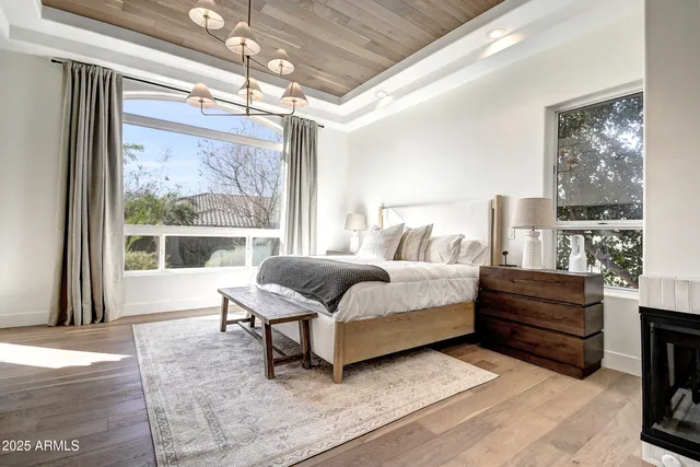 a view of a hallway to a livingroom with wooden floor and furniture