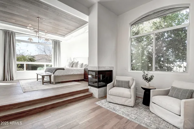 a spacious bedroom with a large bed and a flat tv screen on dresser