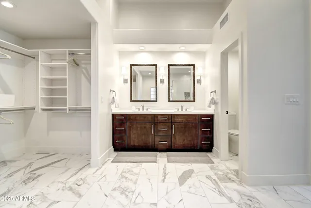 a bathroom with a sink vanity mirror and toilet