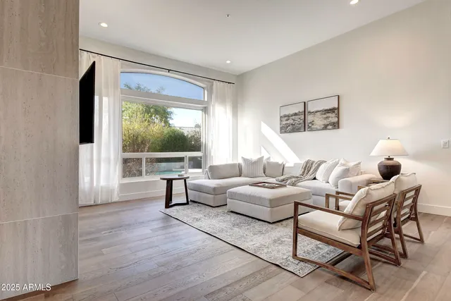 a living room with furniture fireplace and a large window