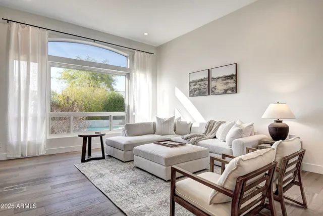 a living room with fireplace furniture and a large window
