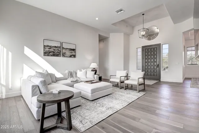 a dining room with furniture a chandelier and wooden floor