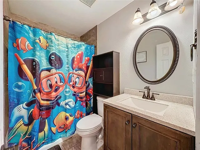 an empty room with ceiling fan and windows